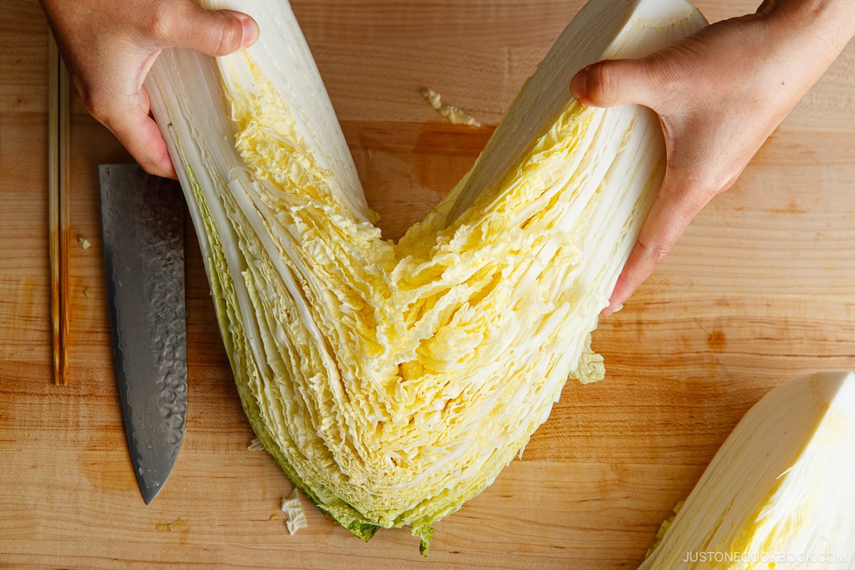 Cut the napa cabbage into quarters and rinse them under water to remove dirt. 