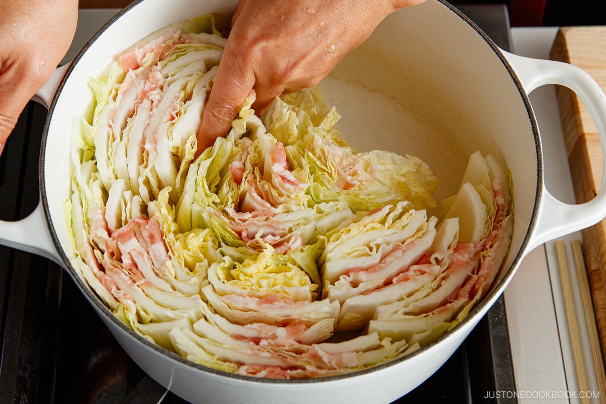 Tightly pack the layered cabbage and pork into a pot, working your way toward the center.