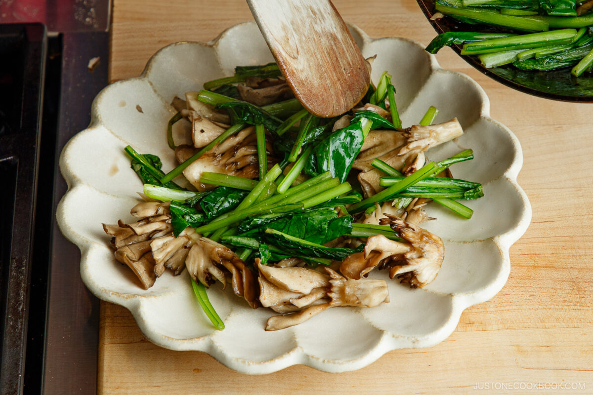 Transfer the green and mushrooms to the plate.