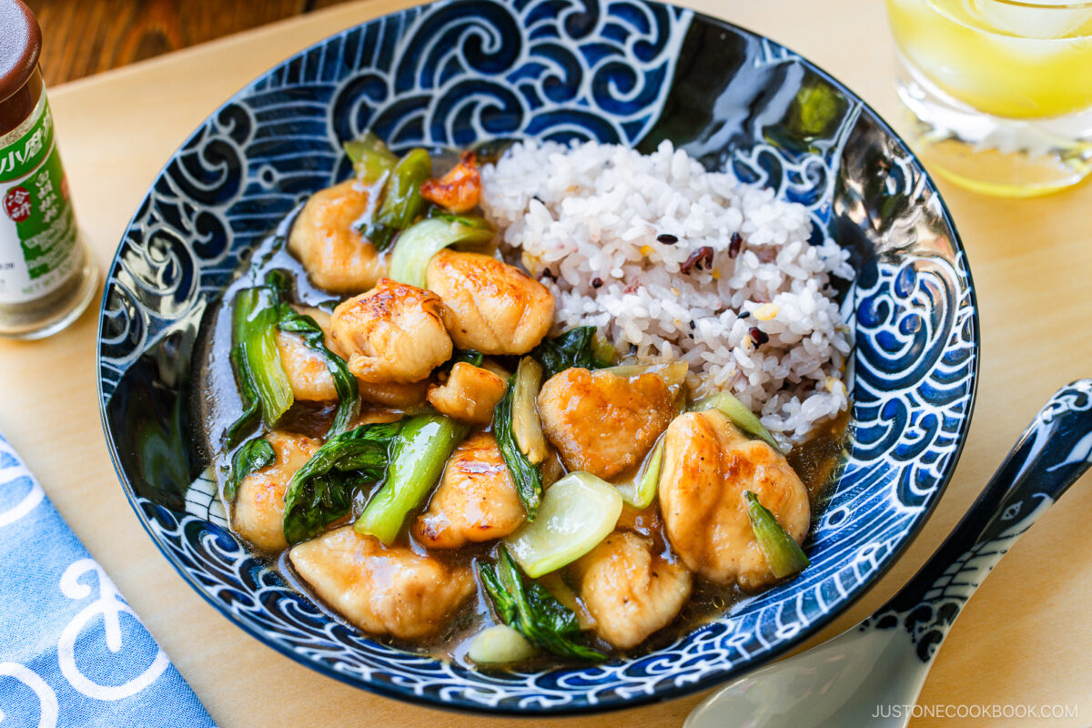 A large shallow bowl containing multi-grain rice and Chicken Bok Choy Stir Fry.