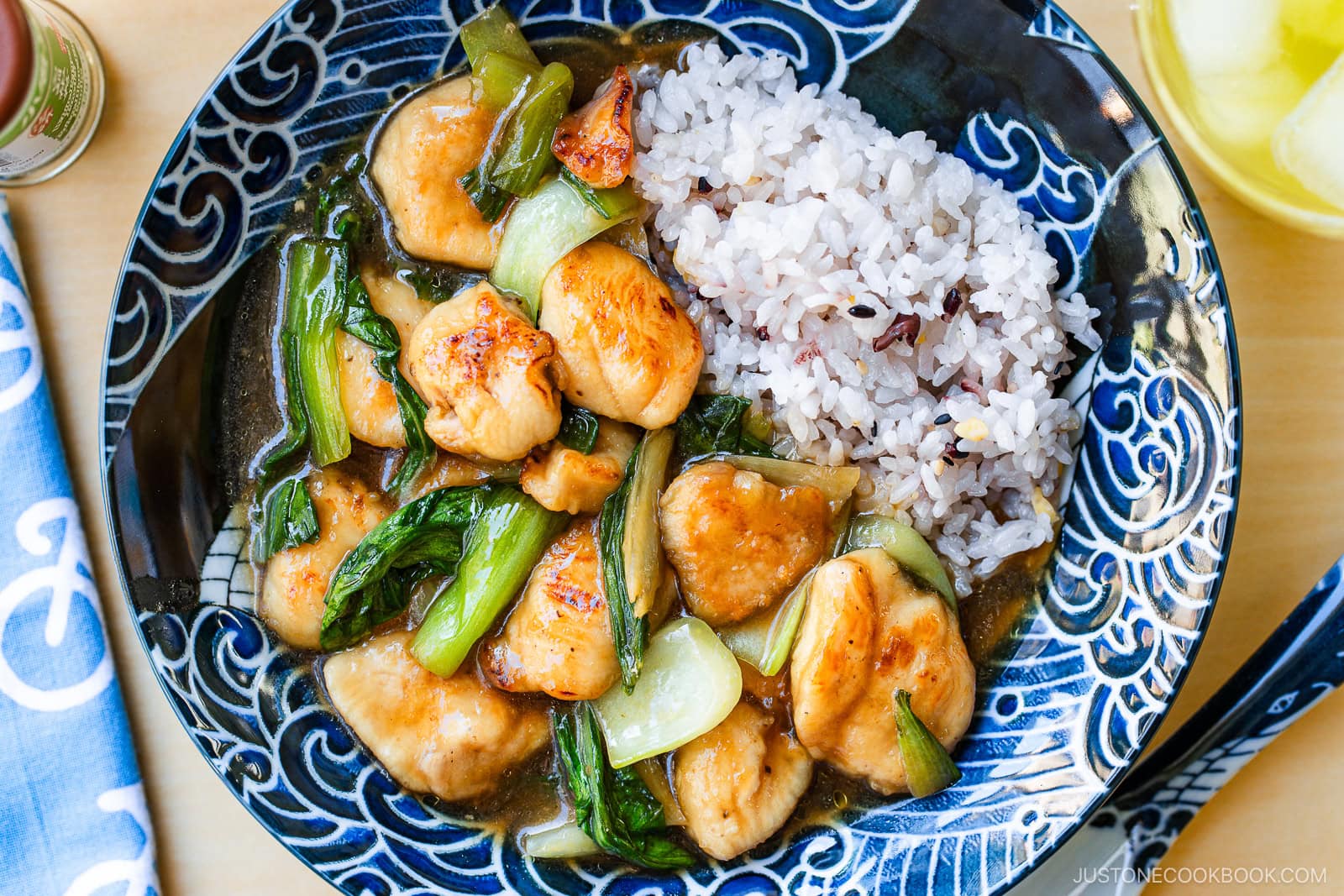 A large shallow bowl containing multi-grain rice and Chicken Bok Choy Stir Fry.