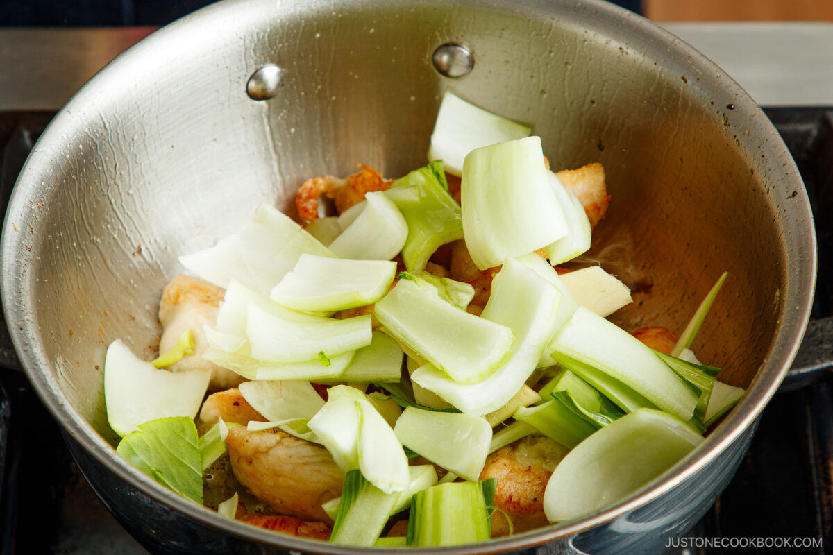 Add the bok choy and ginger slices to the chicken.