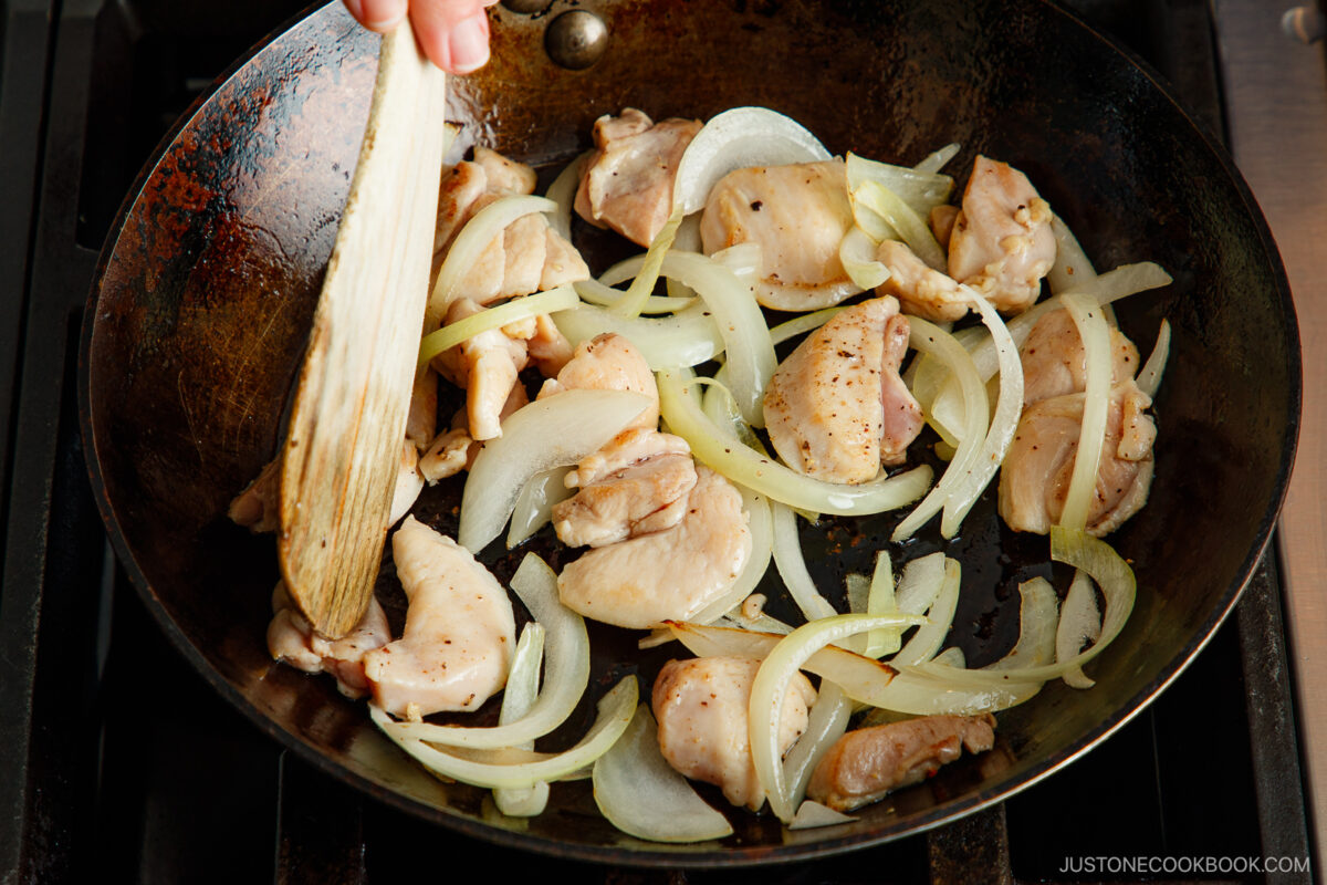 Stir fry the onion and chicken thighs.