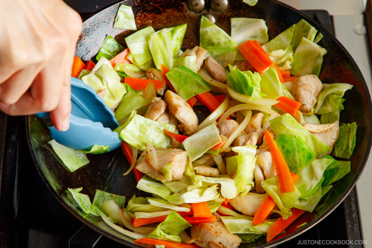 Stir fry the chicken and vegetables.