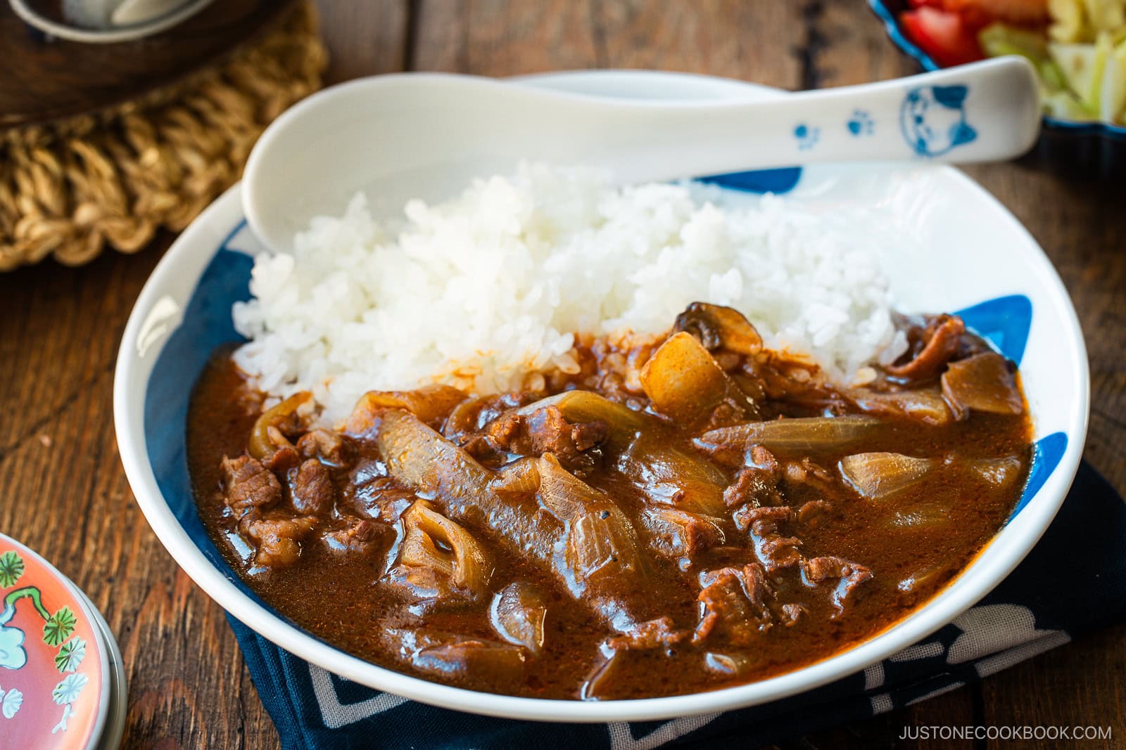 A round shallow bowl containing a bed of steamed rice and Hayashi Rice.