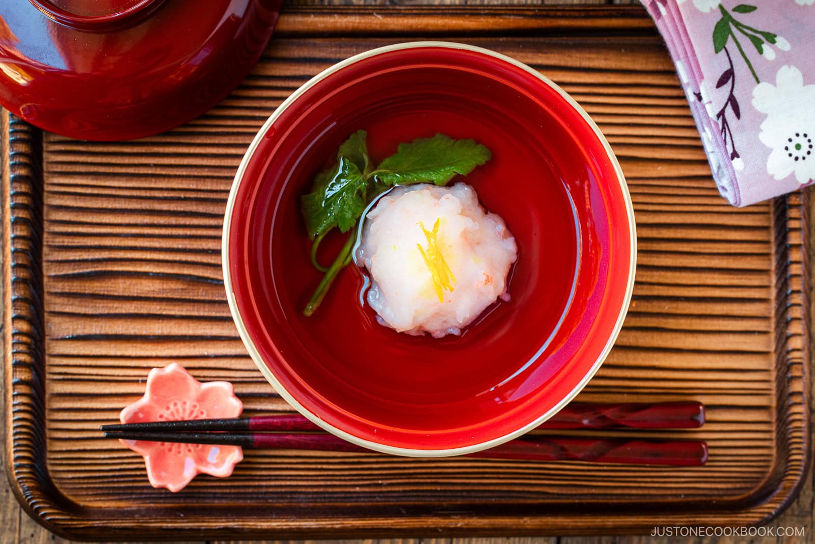 A lacquer bowl containing Ebi Shinjo, a light and fluffy shrimp dumpling, in a flavorful clear soup.