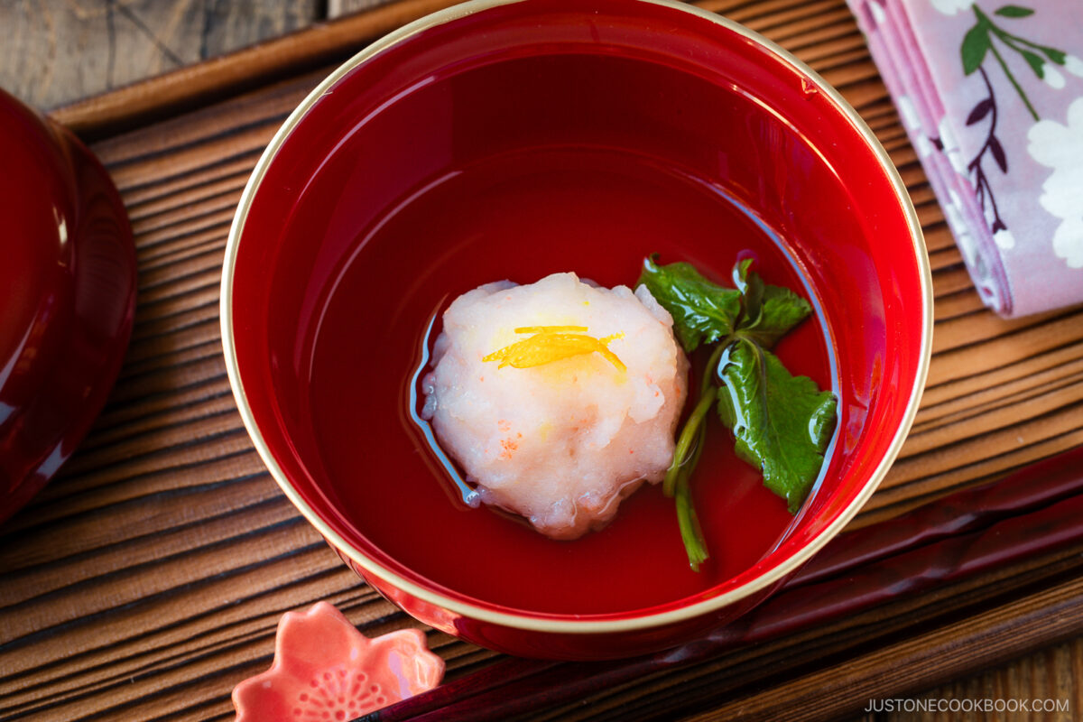 A lacquer bowl containing Ebi Shinjo, a light and fluffy shrimp dumpling, in a flavorful clear soup.