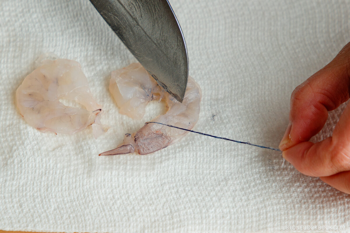 Removing the devein from the shrimp.