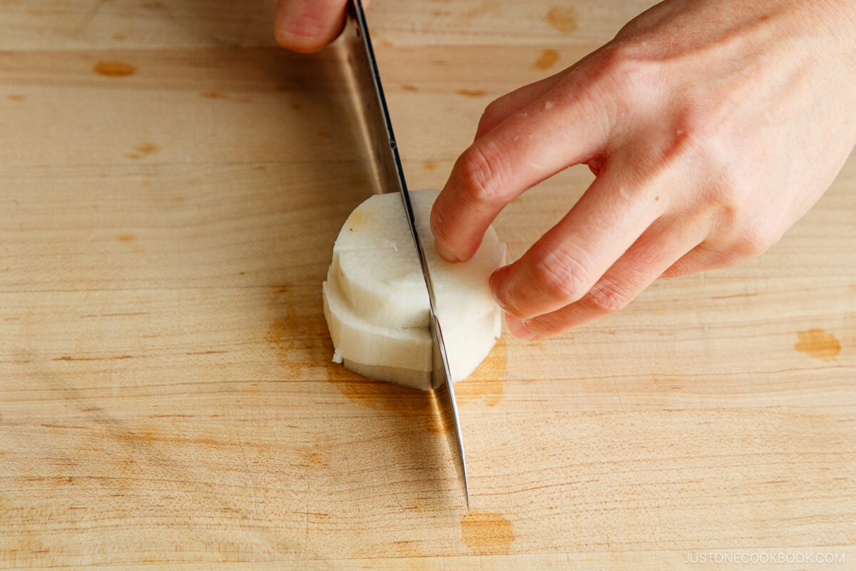 Cutting the nagaimo into cubes with a knife.