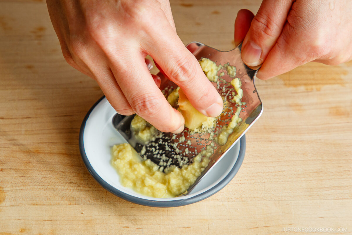 Grating the ginger using a stainless ginger grater.