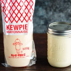 A mason jar of homemade Japanese mayonnaise next to a bottle of Kewpie mayonnaise.