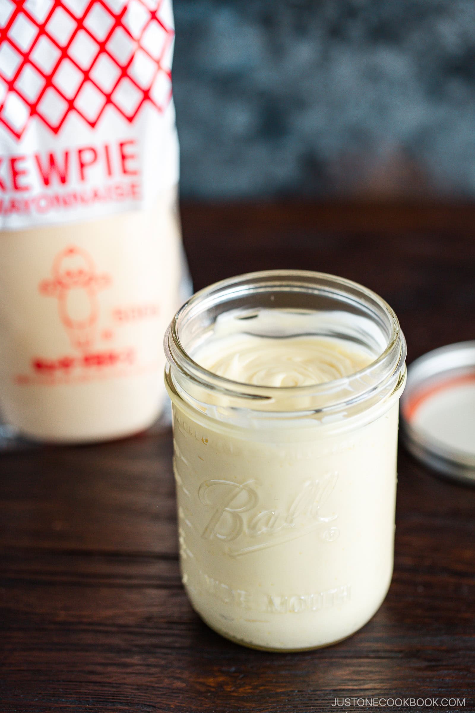 A mason jar of homemade Japanese mayonnaise next to a bottle of Kewpie mayonnaise.