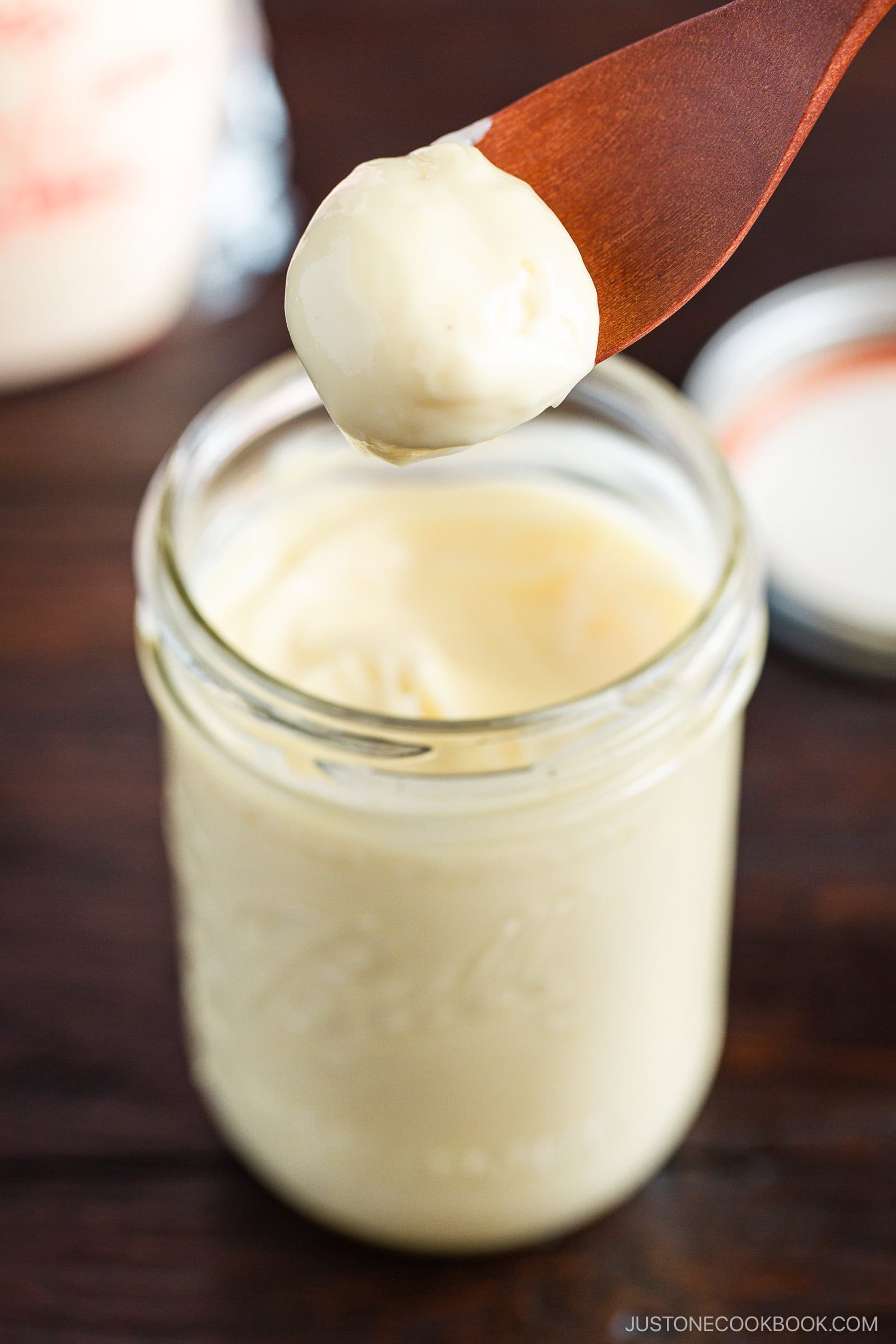 A mason jar of homemade Japanese mayonnaise next to a bottle of Kewpie mayonnaise.