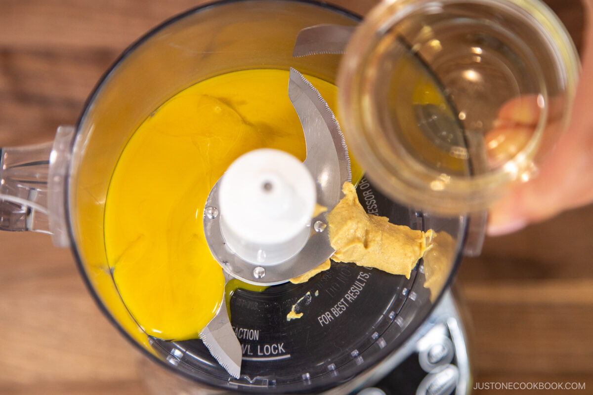 Add egg yolks and the Dijon mustard to the bowl of a small food processor or blender.