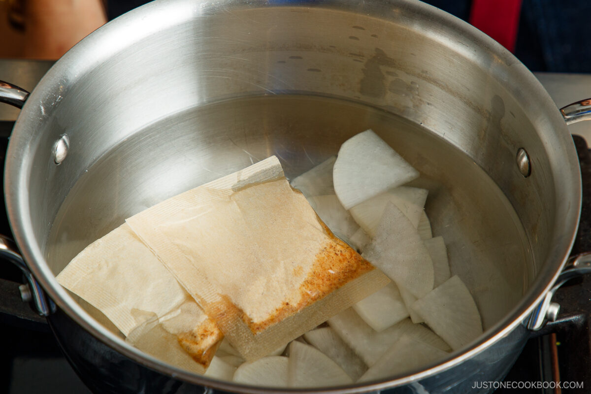 Cook the daikon slices and dashi packets in water.