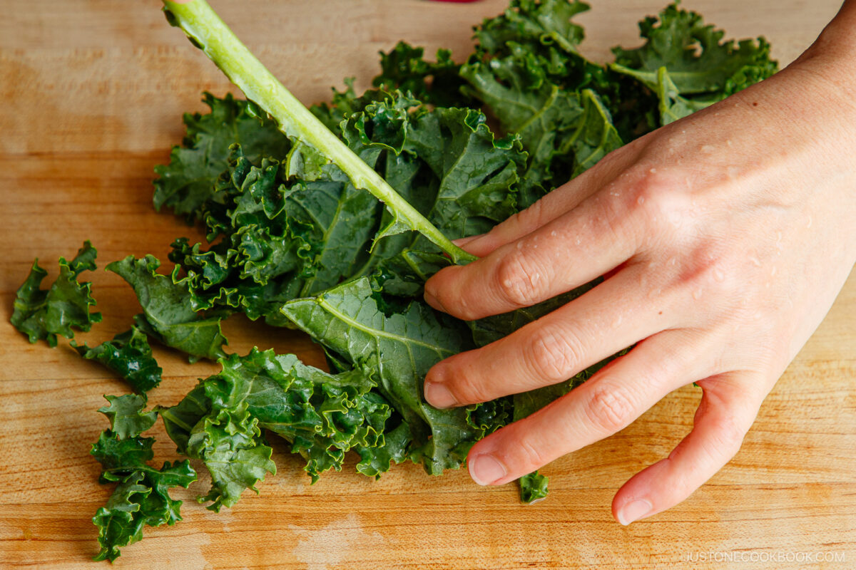 To remove kale leaves from the stem, simply grip the stem with one hand and pull the leaves away with the other, or use a knife to cut along both sides of the stem.