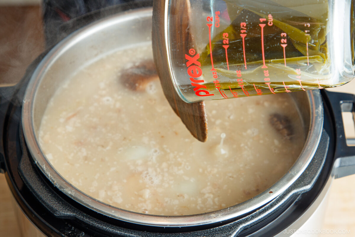 Steamed miso soup with seaweed and tofu in an instant pot or pressure cooker, showcasing Japanese traditional cuisine preparation.