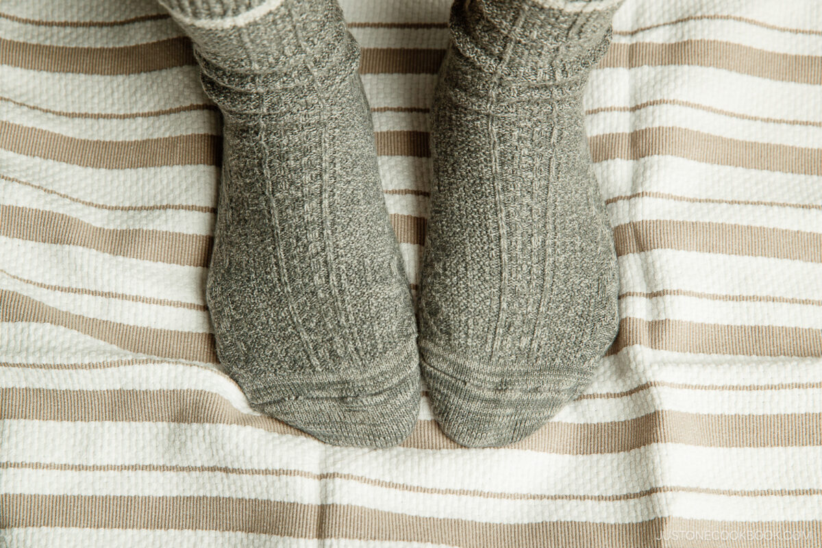 Step on it with your heels. Slowly turn in a circle as you stretch the dough from the center to the edges.