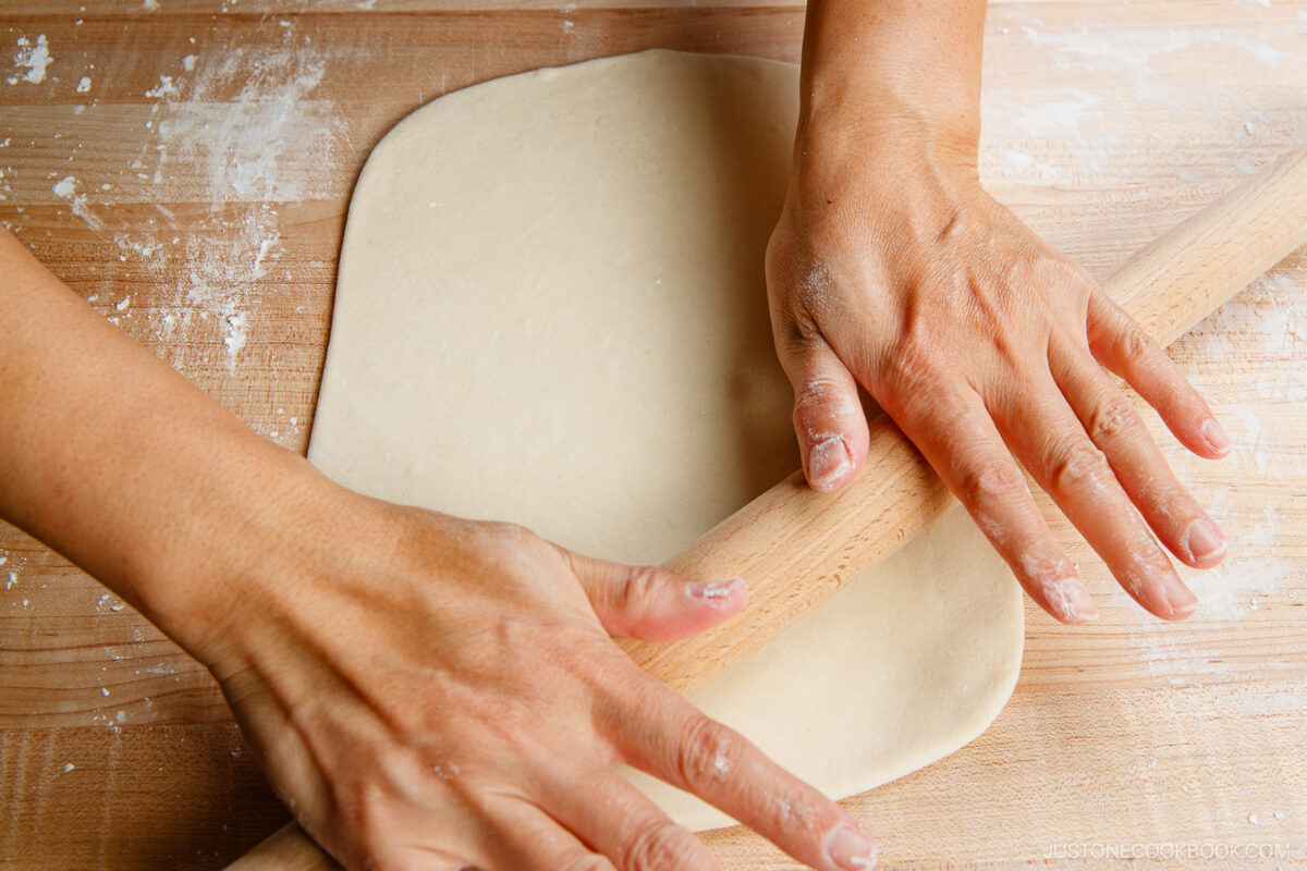 Flatten the dough with your hand on a work surface dusted with potato starch. Roll it out into a rectangle. It should be ⅛ inch (3 mm) thick and 10–12 inches long.