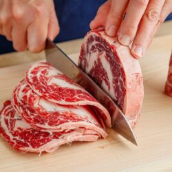 Slicing the block of the ribeye and filet mignon thinly.