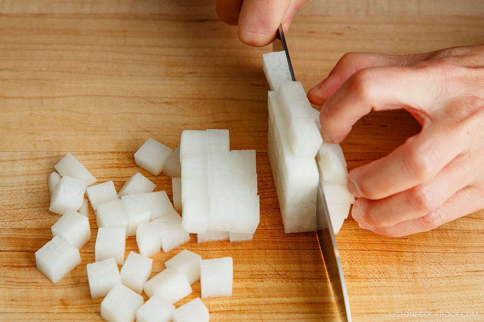 Cutting daikon into small cubes.