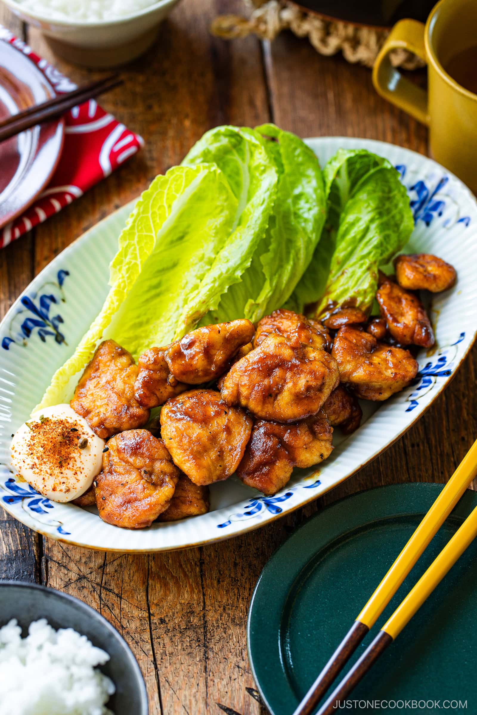 An oval shape plate containing Pan-Fried Curry Chicken garnished with lettuce.