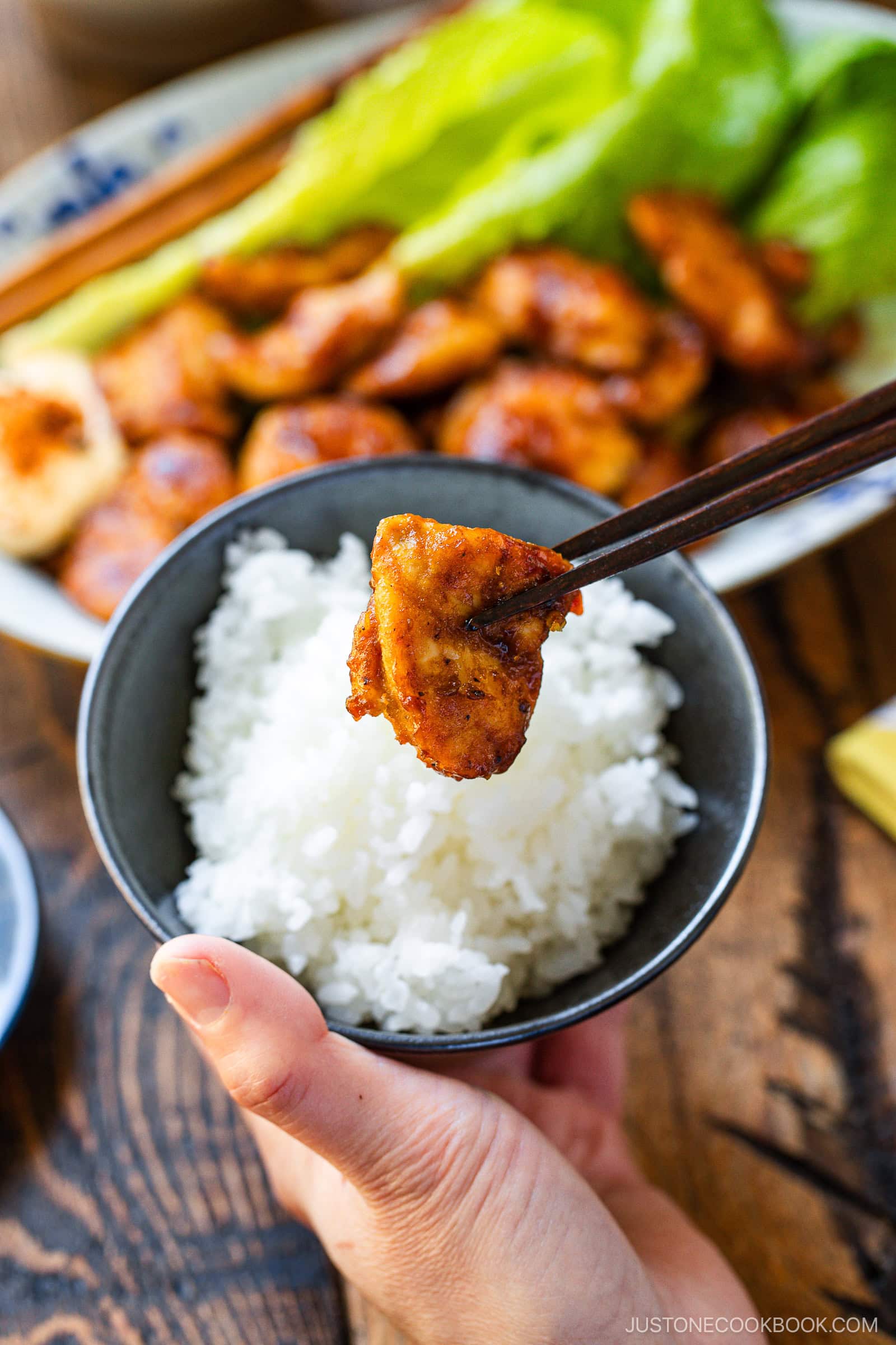 A bowl of steamed rice with Pan-Fried Curry Chicken on top.