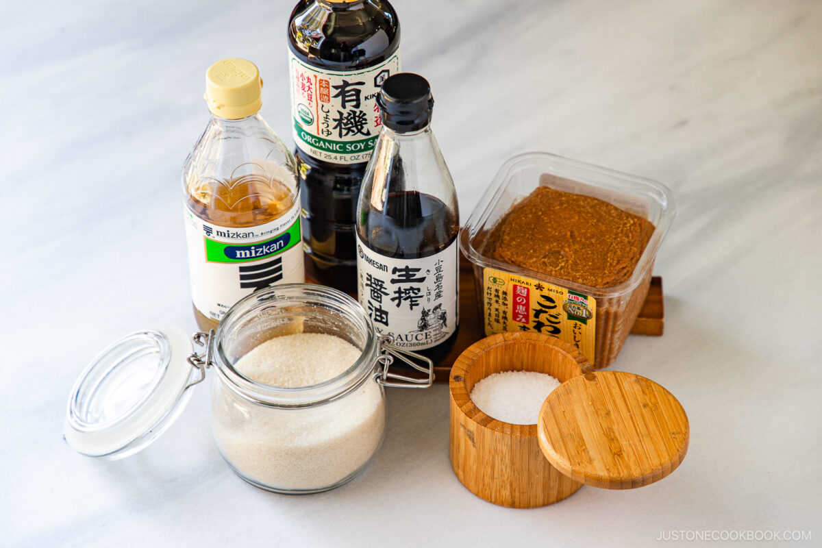 The table with Japanese seasoning staples: sugar, salt, vinegar, soy sauce, and miso.