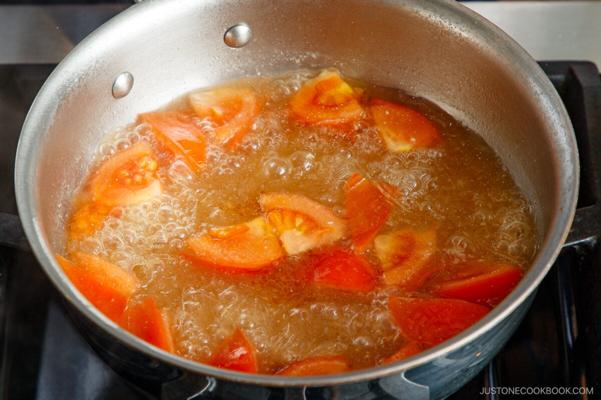 Add the tomatoes to the noodle soup.
