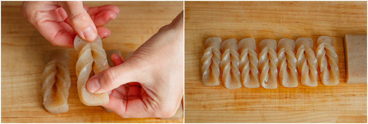 Close-up of hands twisting a piece of greyish konnyaku, and a row of six neatly twisted konnyaku pieces lined up on a wooden cutting board.
