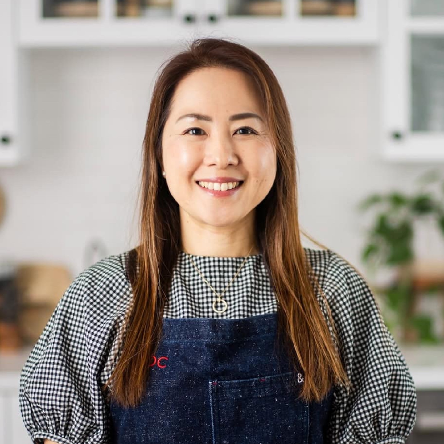 Fresh-faced woman smiling in a cozy kitchen, showcasing Japanese home cooking and recipes featured on Just One Cookbook, with a warm and inviting atmosphere.