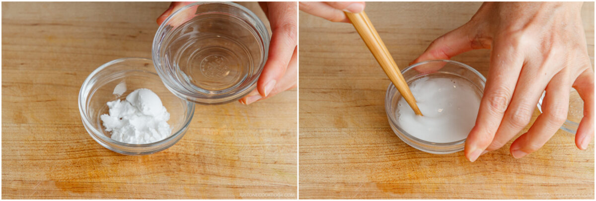 Two side-by-side images: On the left, a hand holds a small bowl of water above a bowl of white baking soda. On the right, a hand stirs the water and baking soda mixture with a wooden stick on a wooden surface.