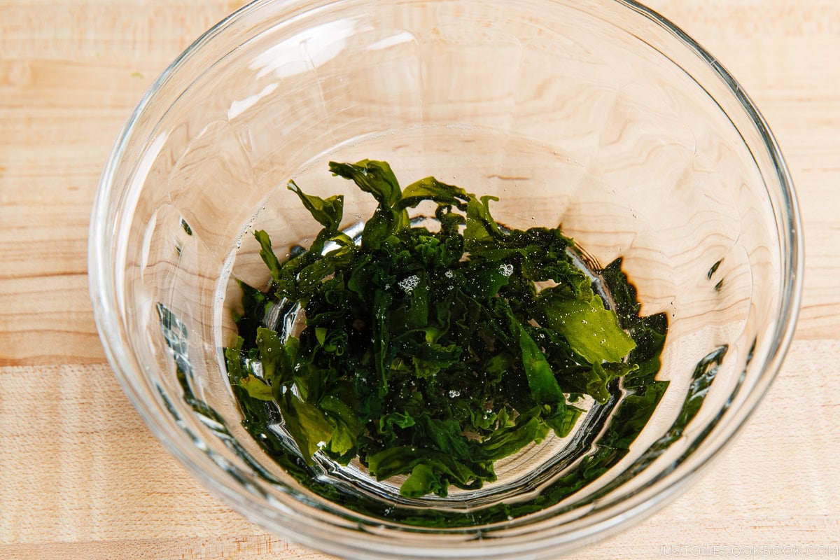 Rehydrating dried wakame seaweed in water.