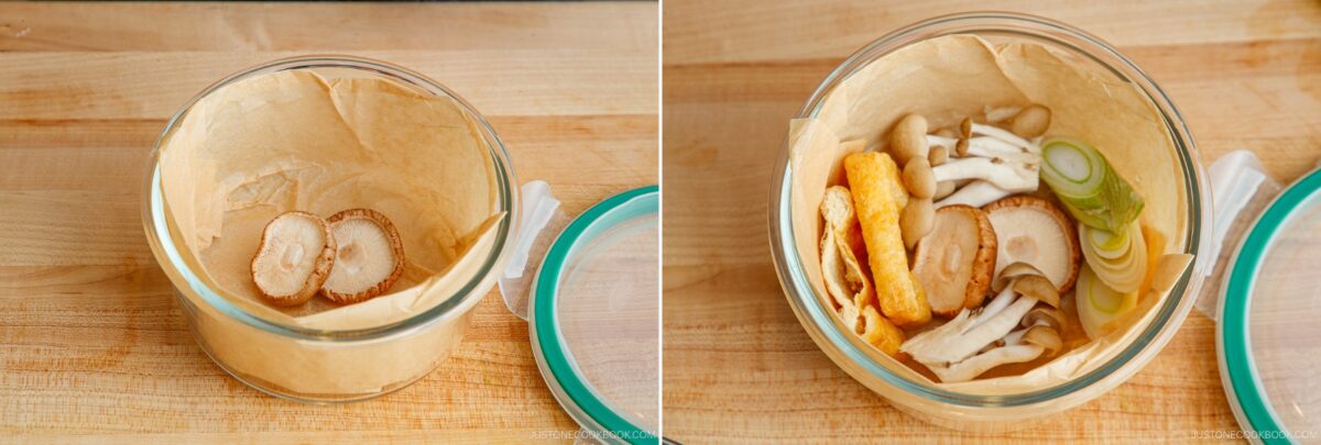 Two glass containers lined with parchment paper on a wooden surface, prepped for a Japanese hot pot meal prep. The left holds three sliced mushrooms; the right features assorted mushrooms and green onion. Turquoise lids rest nearby.