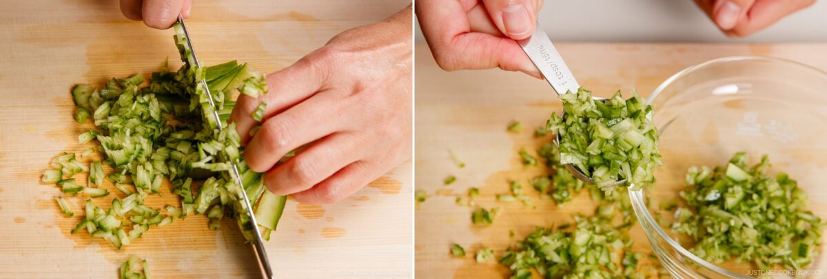 A person finely chops cucumber on a wooden cutting board, then uses a measuring spoon to transfer the chopped cucumber into a glass bowl, preparing ingredients for chicken nanban.